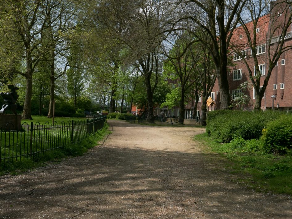 a dirt road in front of a brick building